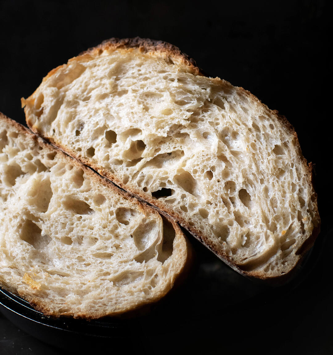Naturally-leavened sourdough bread cut in half.