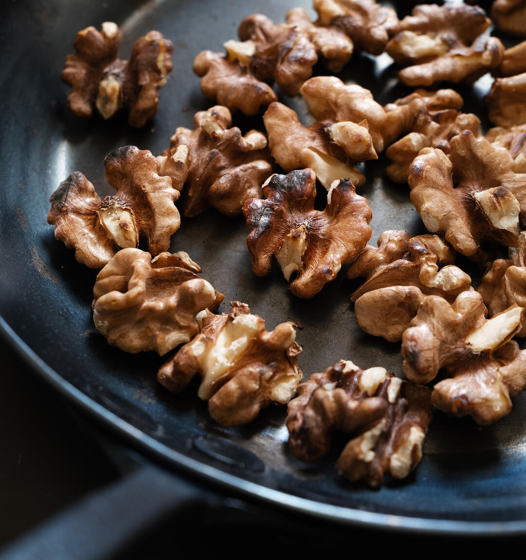 Toasted walnuts in a carbon steel pan