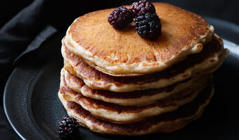 Stack of sourdough pancakes with mulberries.