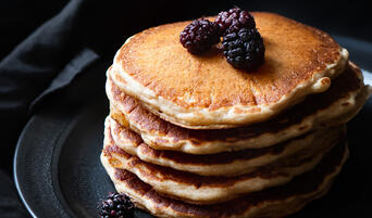 Stack of sourdough pancakes with mulberries.