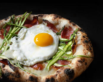 Naturally-leavened (sourdough) pizza with asparagus, speck, and a fried egg.