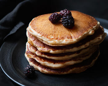 Stack of sourdough pancakes with mulberries.
