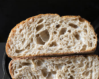 Naturally-leavened sourdough bread cut in half.