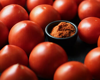 Whole Celebrity tomatoes and a bowl of tomato skin powder.